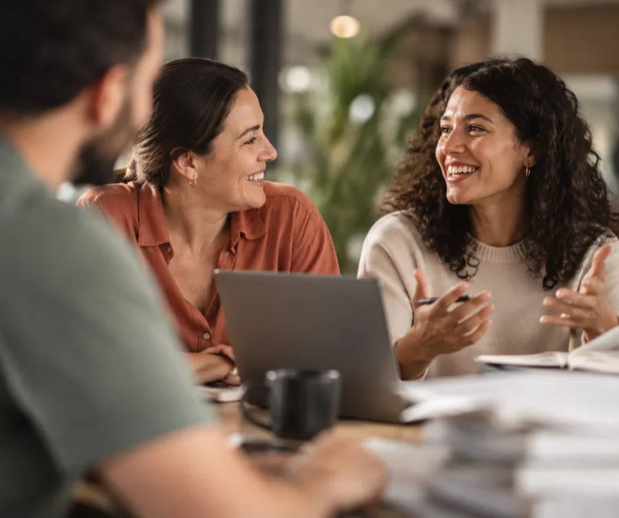 Personas conversando en una oficina con una laptop